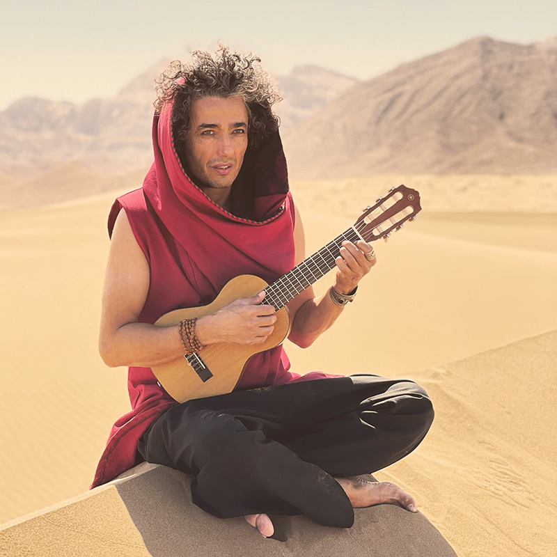 Om playing guitar in the sun of the desert